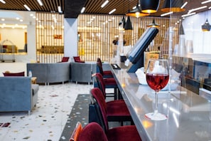 A bar area with seating and a glass of red wine. - Grand Sunny Beach (Nessebar)