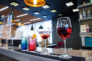 A bar area with a selection of drinks, including a red wine glass and two iced cocktails. - Grand Sunny Beach (Nessebar)