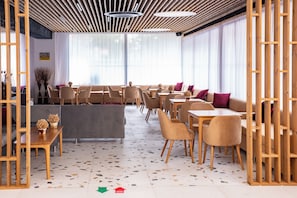 Een modern interieur met een zithoek, tafels en een vloer met een patroon.