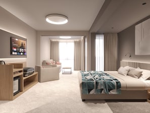 Een moderne hotelkamer met een bed, een zithoek, een televisie en een minibar.