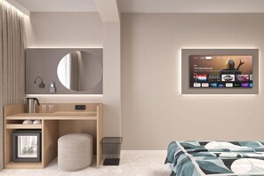 A modern bedroom with a bed, a desk, a mirror, and a wall-mounted TV displaying a streaming service interface. - Grand Sunny Beach (Nessebar)