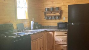 A kitchen with wooden walls, a stove, a refrigerator, and a window. - Hot Tub, Fire Ring, Charcoal Grill, Hocking Hills, Buckeye Lake, Legend Valley (Somerset)
