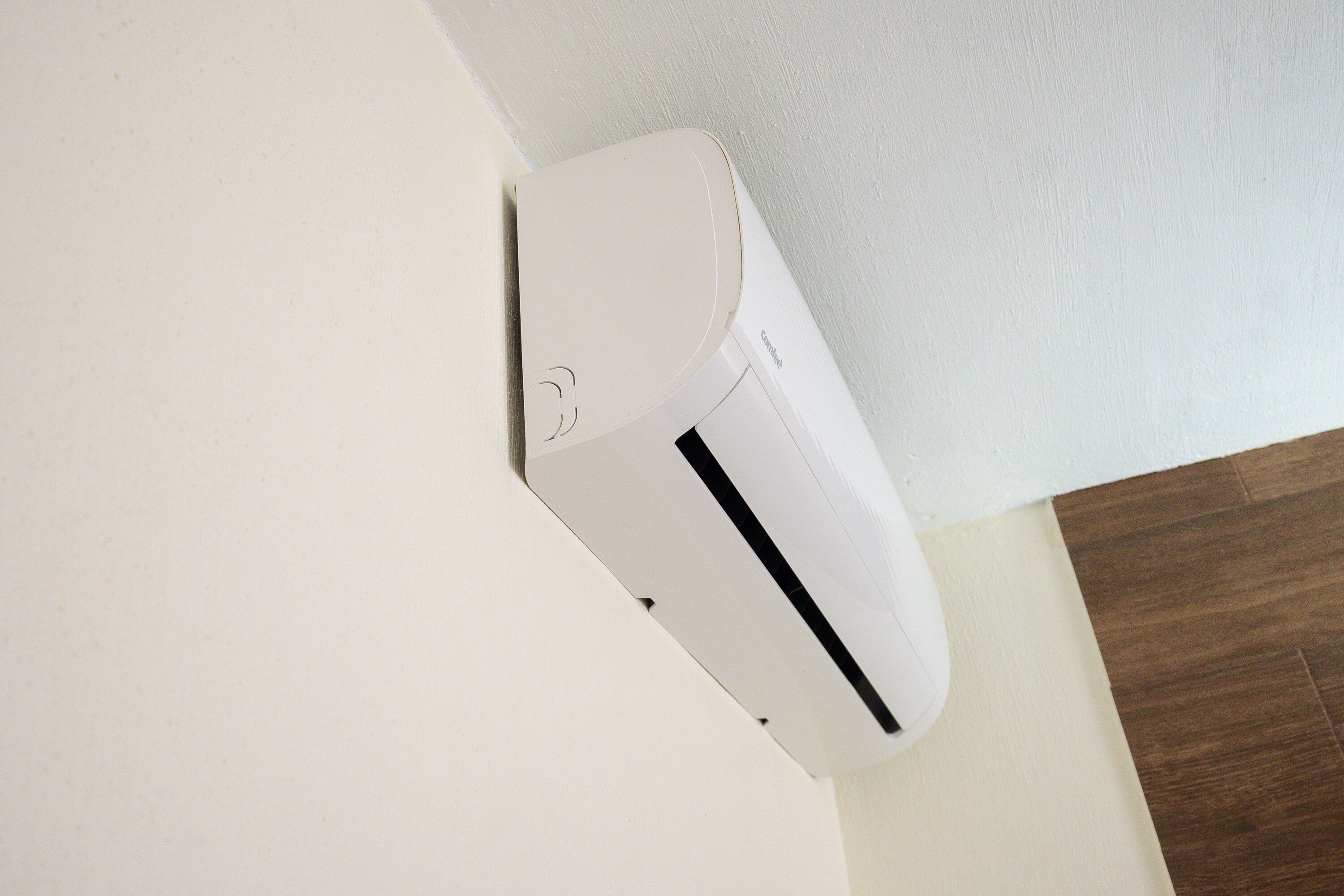 Eine weiße Klimaanlage an einer Wand befestigt.