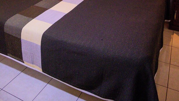 A hotel room with a large bed, wooden headboard, and two bedside lamps. - Hotel Acuario  (Ocotlan)