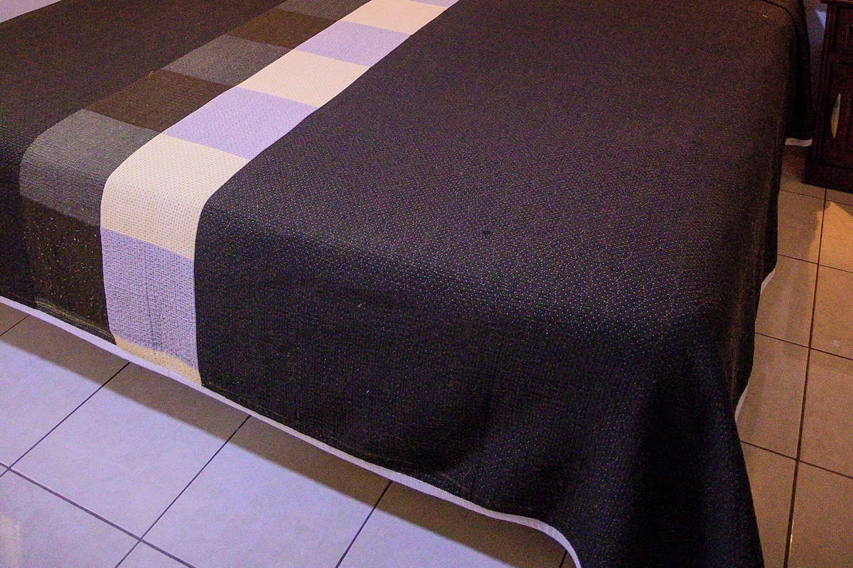 A hotel room with a large bed, wooden headboard, and two bedside lamps.
