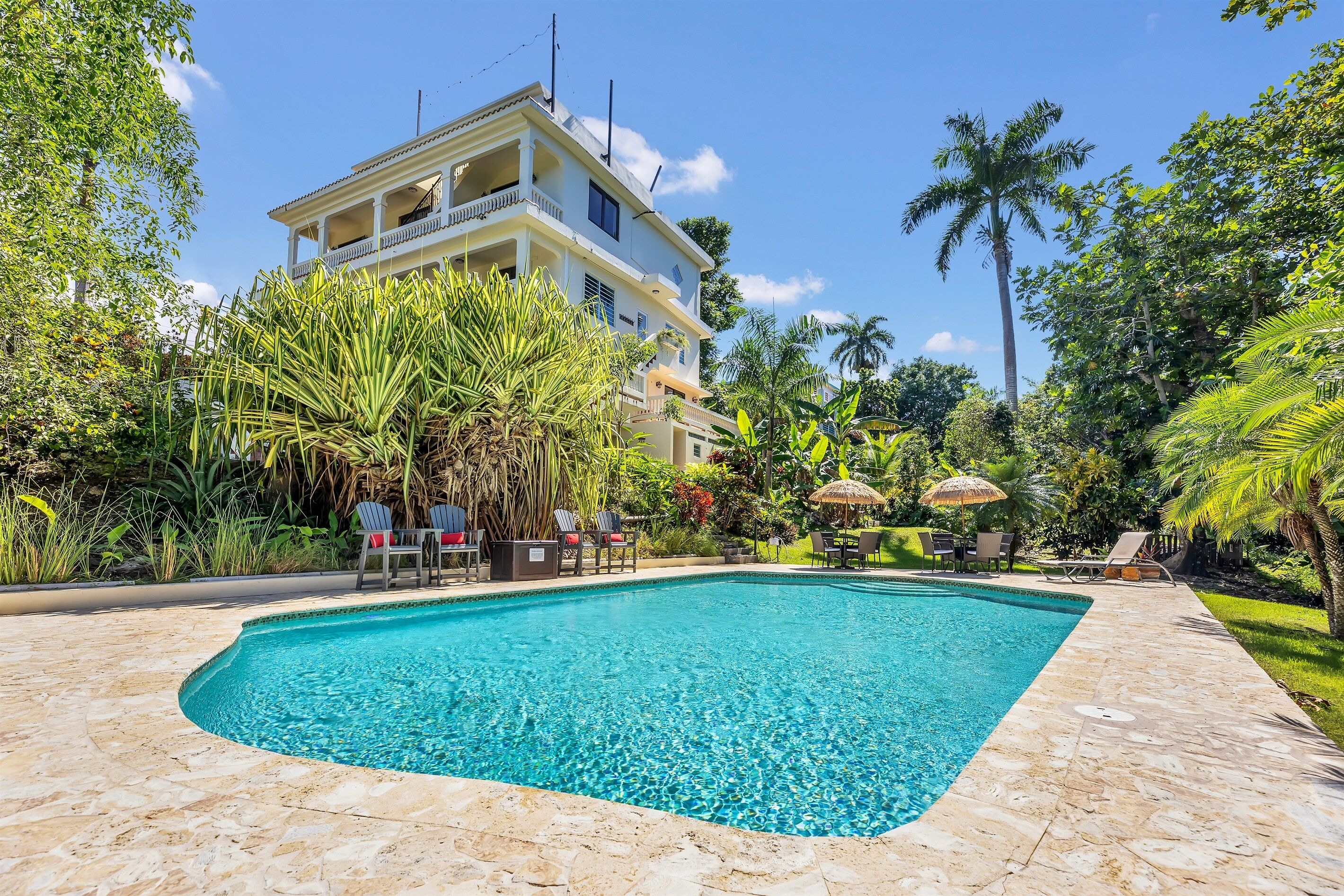 A swimming pool with lounge chairs and a building in the background.