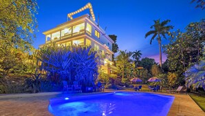 A large, multi-story building with a swimming pool in the foreground. - Casa D'Palma-steps to Sandy Beach! (Rincón)