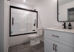Bañera con ducha, secador de pelo, toallas, papel higiénico