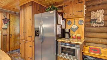 Una cocina con armarios de madera, un refrigerador de acero inoxidable, una cafetera y una estufa.
