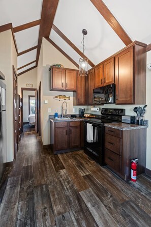 A kitchen with wooden cabinets, a stove, and a microwave.