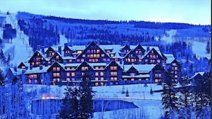 A large lodge with multiple log cabins, surrounded by snow-covered trees and a ski slope. - Ritz-Carlton Beaver Creek -- LUXURIOUS-2BR,2Bath, SLOPESIDE & inside hotel (Beaver Creek)