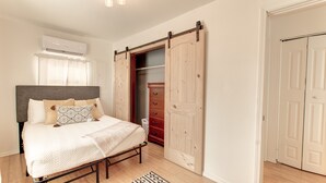 A bedroom with a bed, a wardrobe, and a sliding door closet.