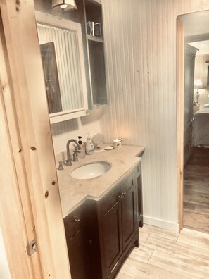 Een badkamer met een houten wastafelmeubel, een wastafel en een spiegel.