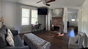 A living room with a gray sofa, a coffee table, and a fireplace. - Getaway Country Cottage - Entire house - Unique Find /Outdoor Decking           (New Bern)