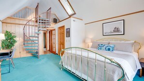 Een slaapkamer met een bed, een trap, een bureau en een raam.
