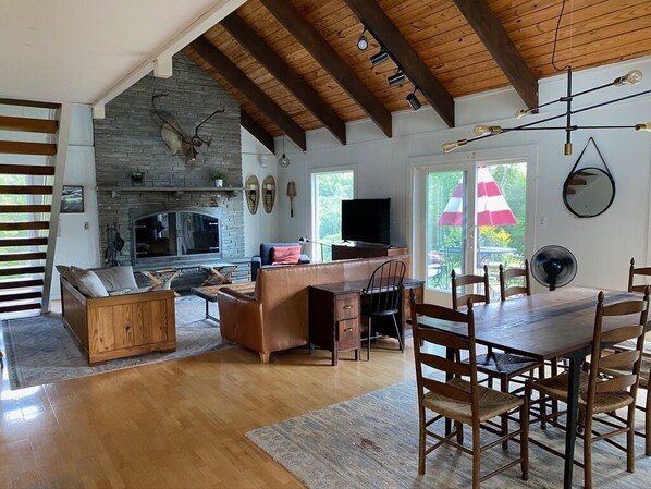 Cozy living area with a stone fireplace, comfortable sofa, and dining table for four.
