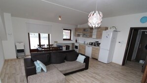 A modern apartment with a living room, dining area, and kitchen.