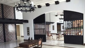 A spacious lobby with a high ceiling, chandeliers, a reception desk, and a seating area with chairs and tables. - Penthouse with amazing view beach/city (Carolina)