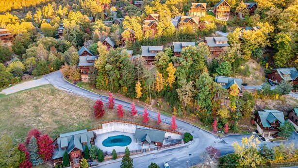 Un resort con varias cabañas, una piscina y un camino sinuoso.