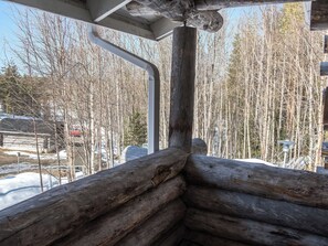 A log cabin interior with a view of a snowy landscape and leafless trees. - Rukankuukkeli c 24 by Interhome (Kuusamo)