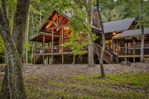 A cabin with a wooden exterior, multiple decks, and a staircase leading to the upper levels. - Riverscape | Ellijay, GA (Ellijay)