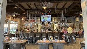 Un restaurante con techos altos, vigas a la vista y una zona de bar.