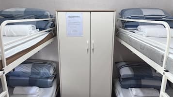 A bunk bed room with a central wardrobe and a sign on the wardrobe.
