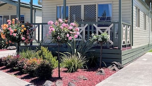 A mobile home with a covered porch, a name "Jayco" on the front, and a garden with various plants and flowers. - Paynesville Holiday Park (Paynesville)