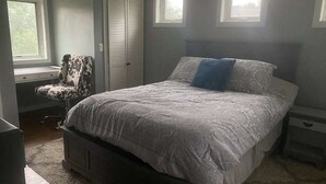 A bedroom with a large bed, a chair, a nightstand, and a window. - Red Barn Retreat - Shawangunk Mountains Getaway (Gardiner)