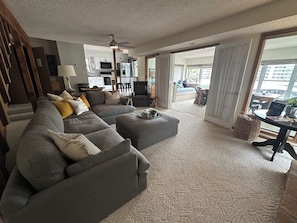 A living room with a sectional sofa, ottoman, and a dining area with a table and chairs. - Quiet retreat, Deep Calm water. NOTE: NIGHTLY RATE INCLUDES FEES (Eldon)