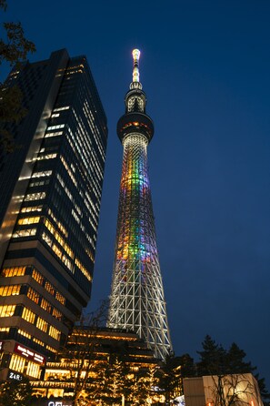 Una torre alta con un colorido espectáculo de luces, rodeada de edificios modernos.