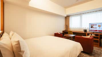 Une chambre d’hôtel avec un grand lit, un bureau, une chaise et un téléviseur.
