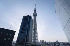 Un rascacielos moderno con una estructura de torre distintiva, rodeado de otros edificios de gran altura.