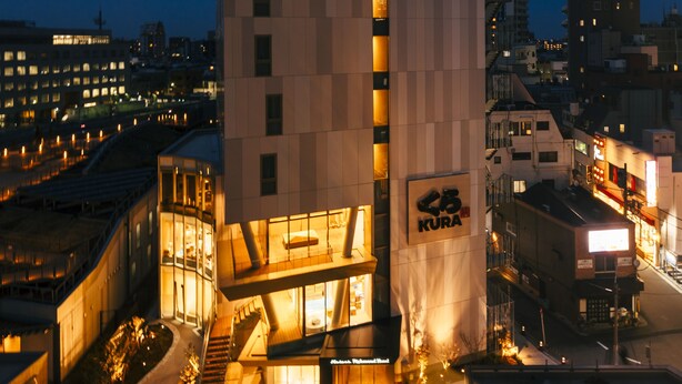 A modern building with a prominent vertical section and a sign reading "KURA".