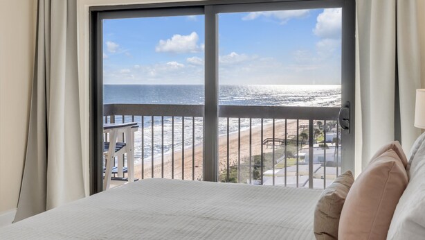 Habitación de hotel con un amplio ventanal con vistas a la playa.