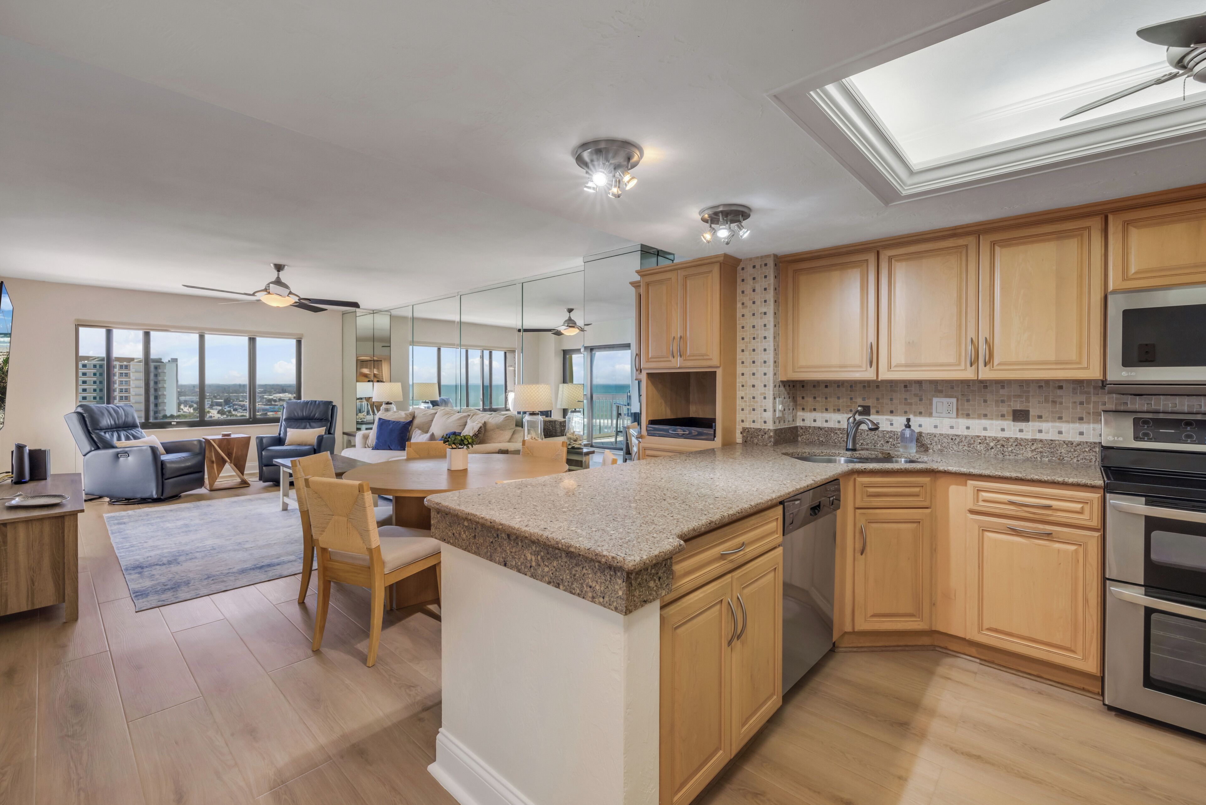 A spacious kitchen with wooden cabinets, a granite countertop, and stainless steel appliances.