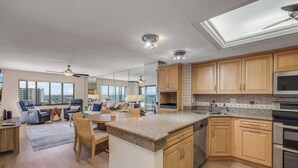 Una cocina amplia con armarios de madera, encimera de granito y electrodomésticos de acero inoxidable.