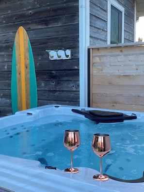 Tinaco con dos copas de vino, una tabla de surf y una pared de madera.