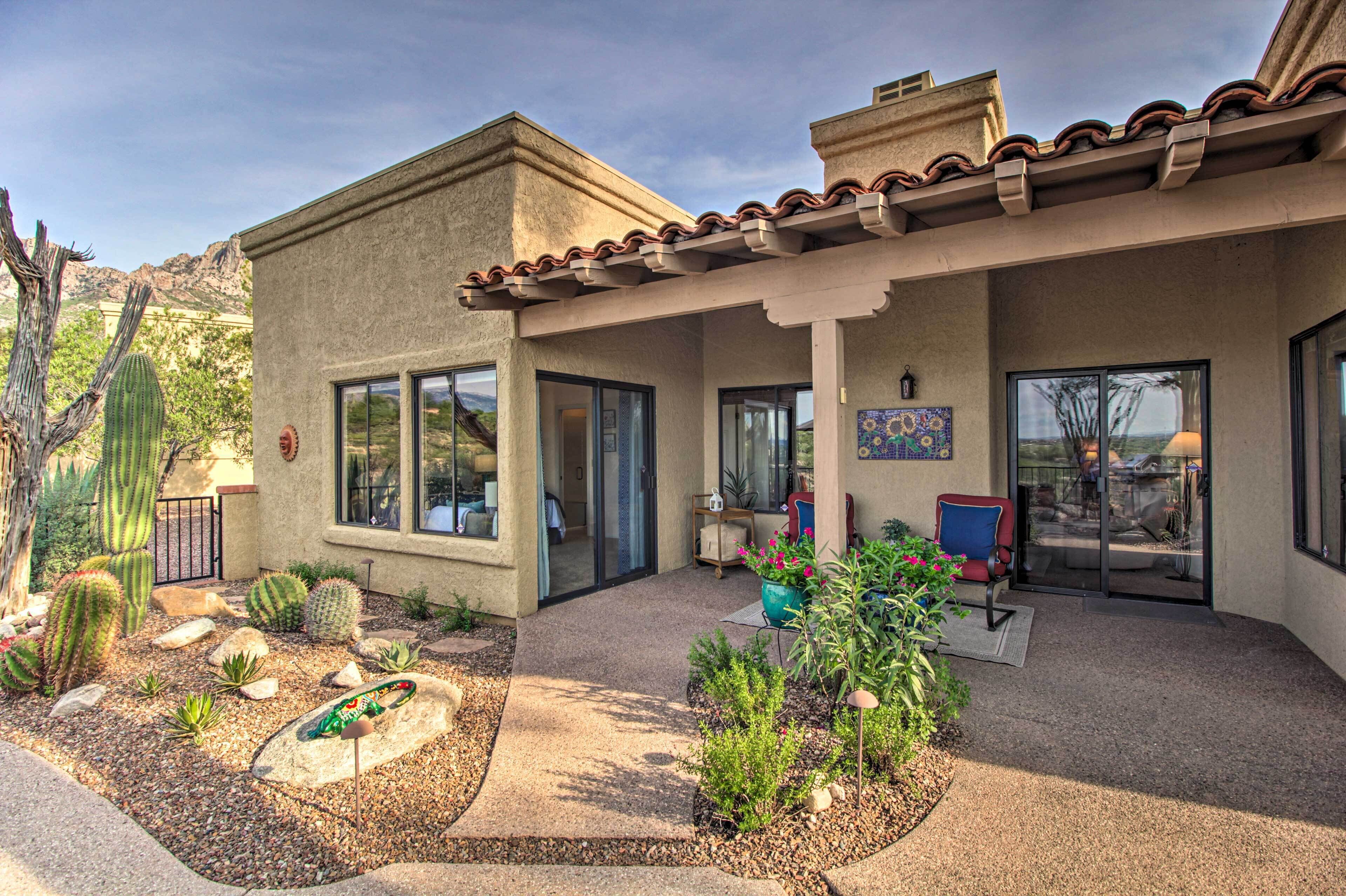 A house with a patio area, a covered porch, and a garden with cacti and succulents.