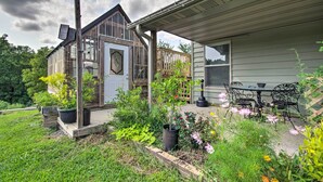 A house with a porch, a wooden deck, and a garden with various plants and flowers. - 'Grace Place' Clark House on Farm: Shared Hot Tub! (Clark)