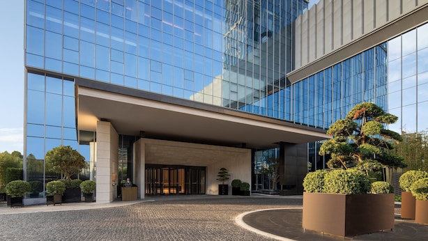 Un edificio moderno con fachada de vidrio y vestíbulo cubierto.