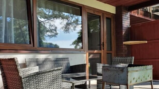 Un espacio al aire libre con mobiliario de mimbre y techo de madera.