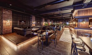 A modern bar with leather seating, a bar counter, and a visible menu. - Novel Centre Point Hotel (Famagusta)