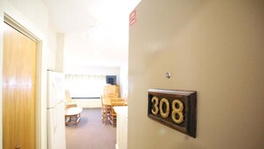 A hallway with a door on the left and a number sign '308' on the wall.