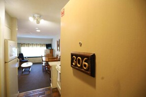 A hallway with a number '306' on the wall, leading to a dining area with chairs and a table. - Spend your Vacation at Waterville Valley! (Waterville Valley)