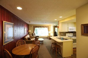 A compact living space with a dining area, kitchen, and seating area.