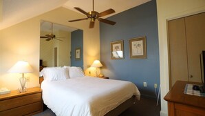 A hotel room with a bed, two bedside lamps, a ceiling fan, a mirror, and a wooden dresser. - Inns of Waterville Valley Loft Unit (Waterville Valley)