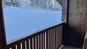 En träbalkong med utsikt över ett snötäckt landskap.