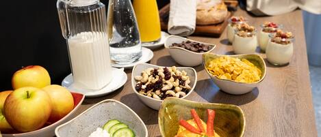 A breakfast table with various food items and beverages.