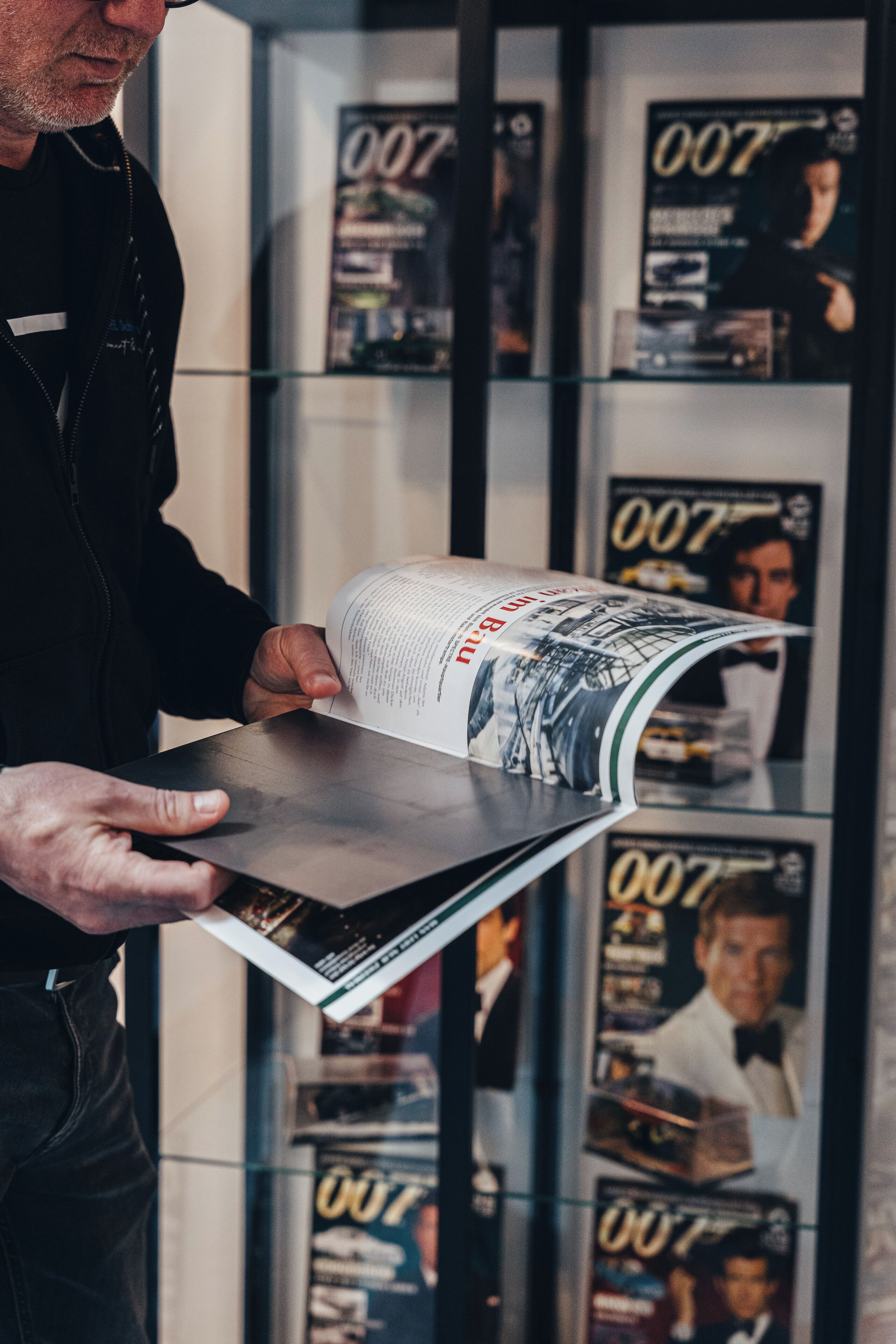 Uma pessoa segurando uma revista com a capa mostrando um edifício.
